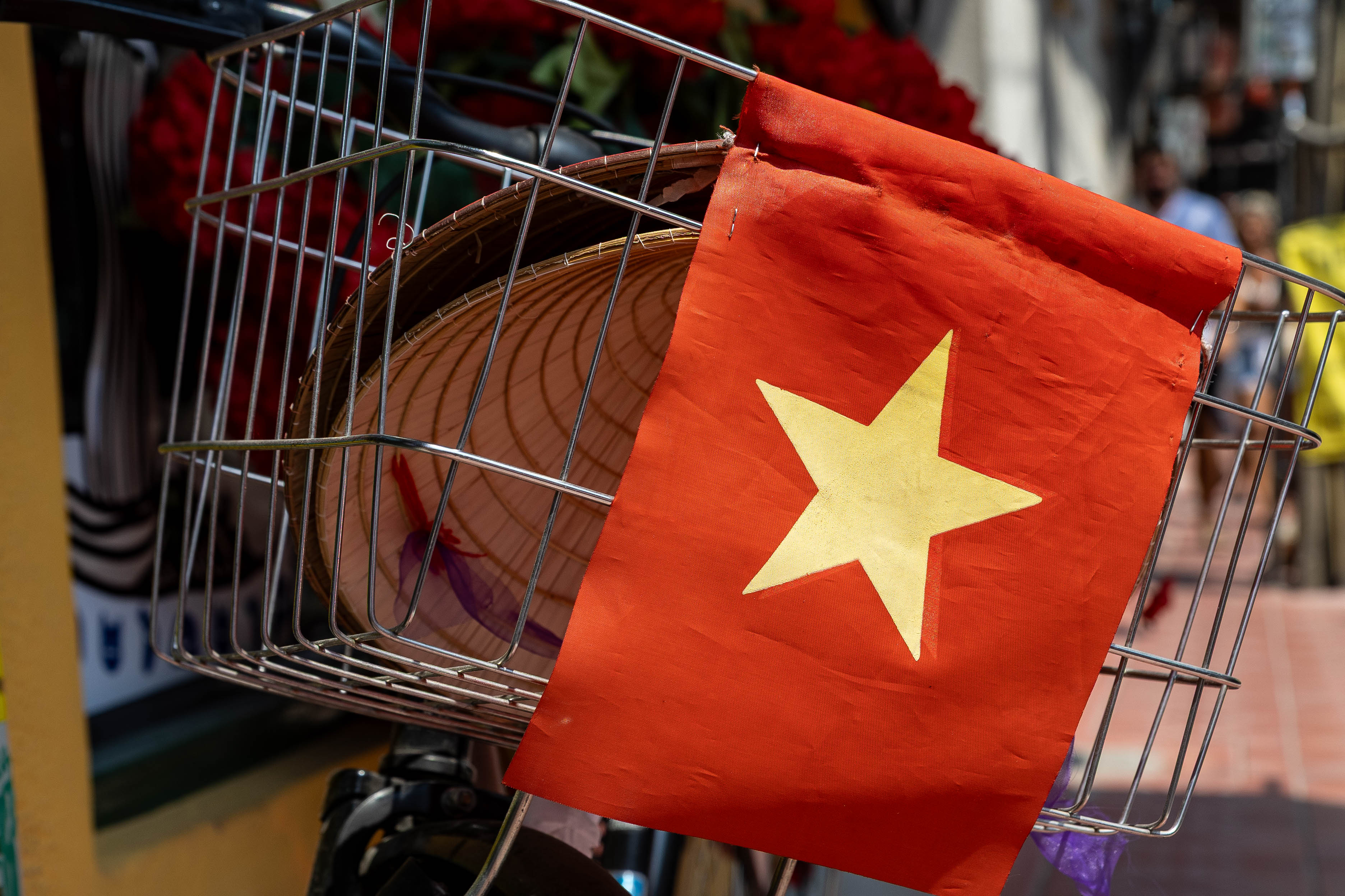 Vietnamese national flag with gold star and traditional conical hat in bicycle basket outside Song Viet at Song Wat, Song Wat Road Bangkok